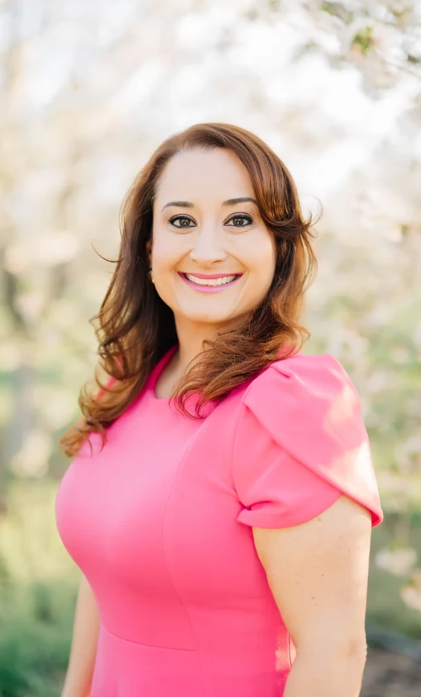 Thaís Marina, founder and owner of Marina's Cleaning Services, wearing a pink dress
